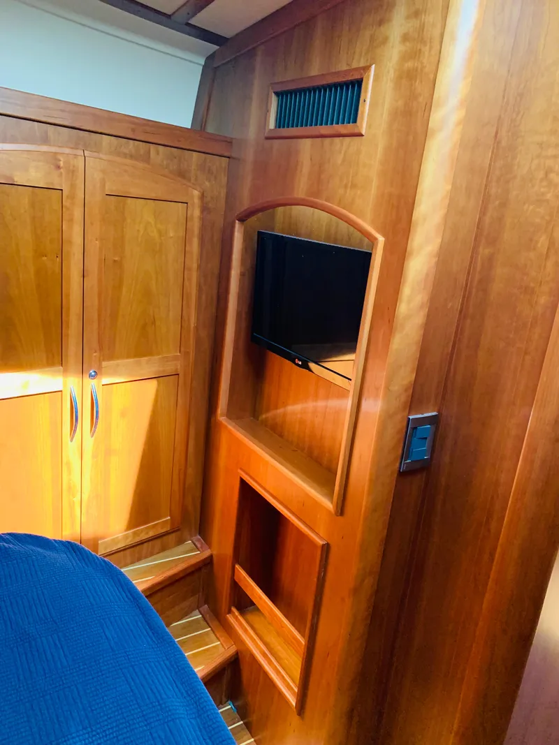 Slide: The Image of 2014 Sabre 48 Salon Express interior with wood cabinetry and mounted TV. - 18