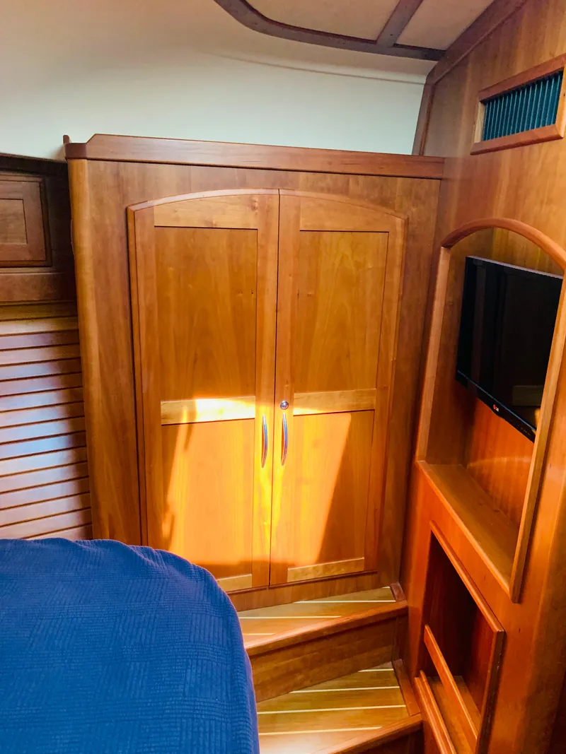 Slide: The Image of 2014 Sabre 48 Salon Express interior with wooden cabinetry and built-in TV. - 19