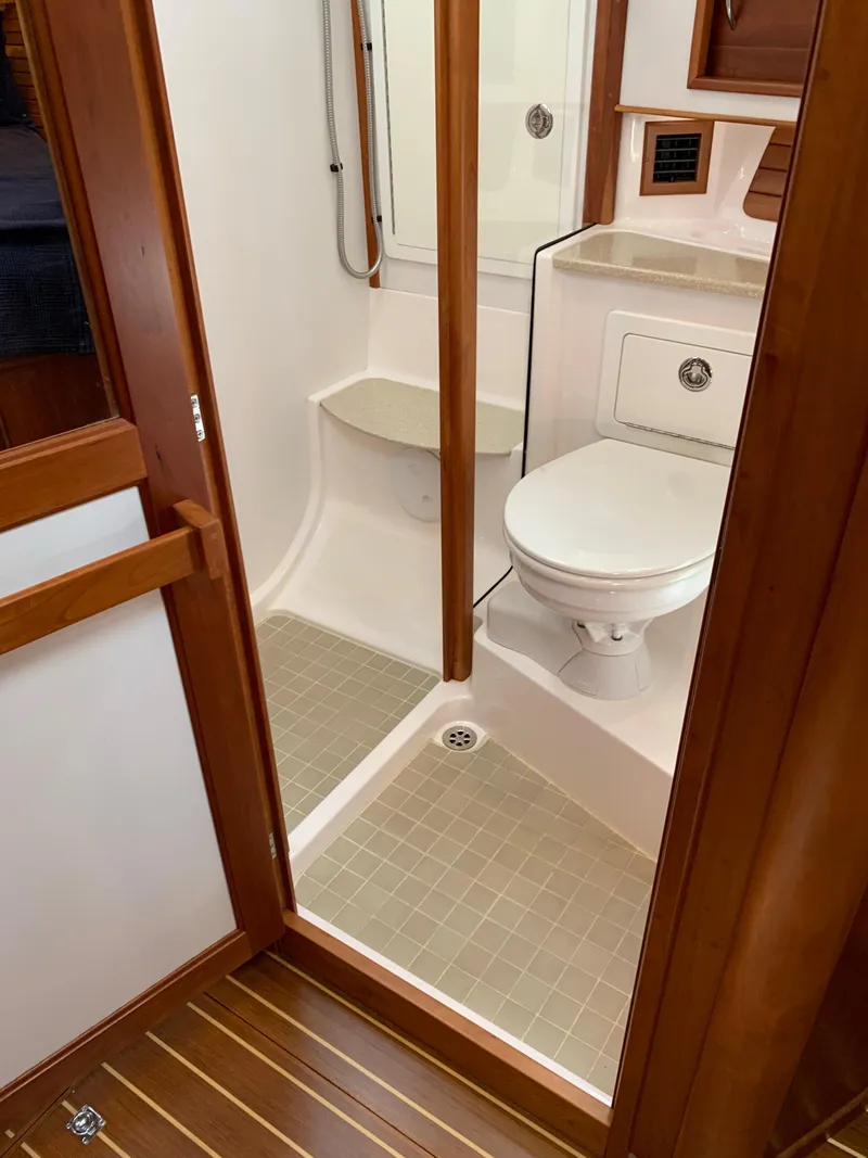 Slide: The Image of 2014 Sabre 48 Salon Express bathroom with shower, toilet, and wooden accents. - 22