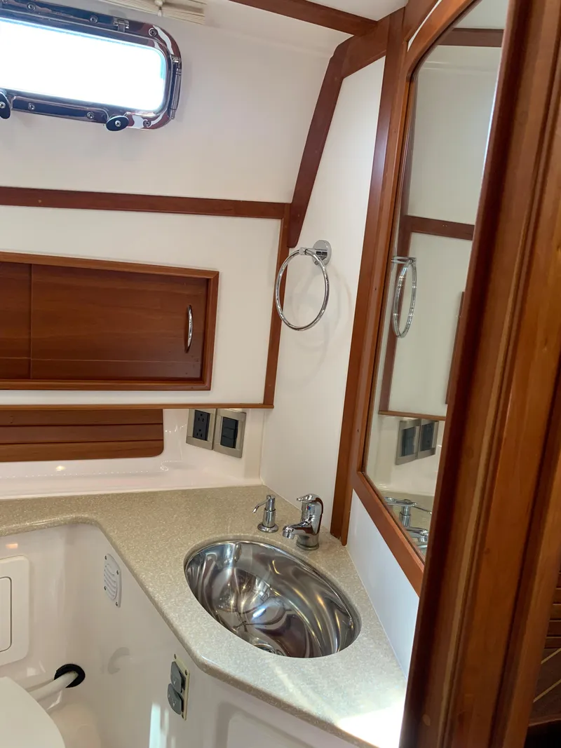 Slide: The Image of 2014 Sabre 48 Salon Express bathroom with wood accents and stainless steel sink. - 23