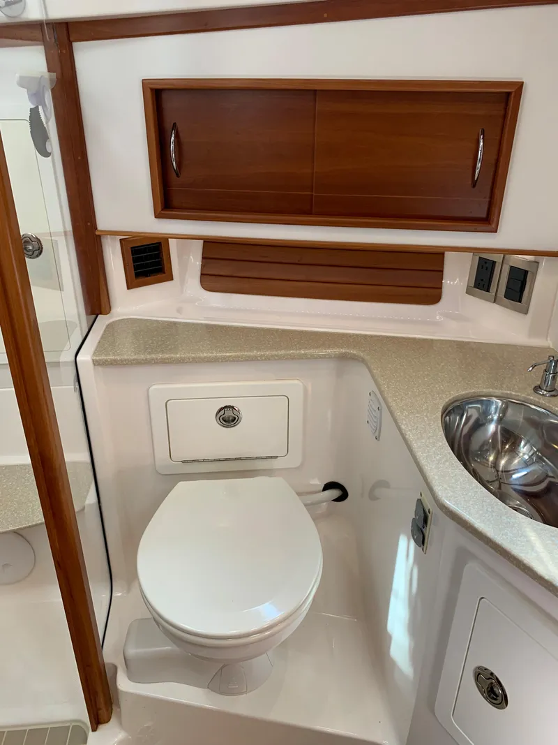 Slide: The Image of 2014 Sabre 48 Salon Express yacht bathroom with modern fixtures and wood cabinetry. - 24