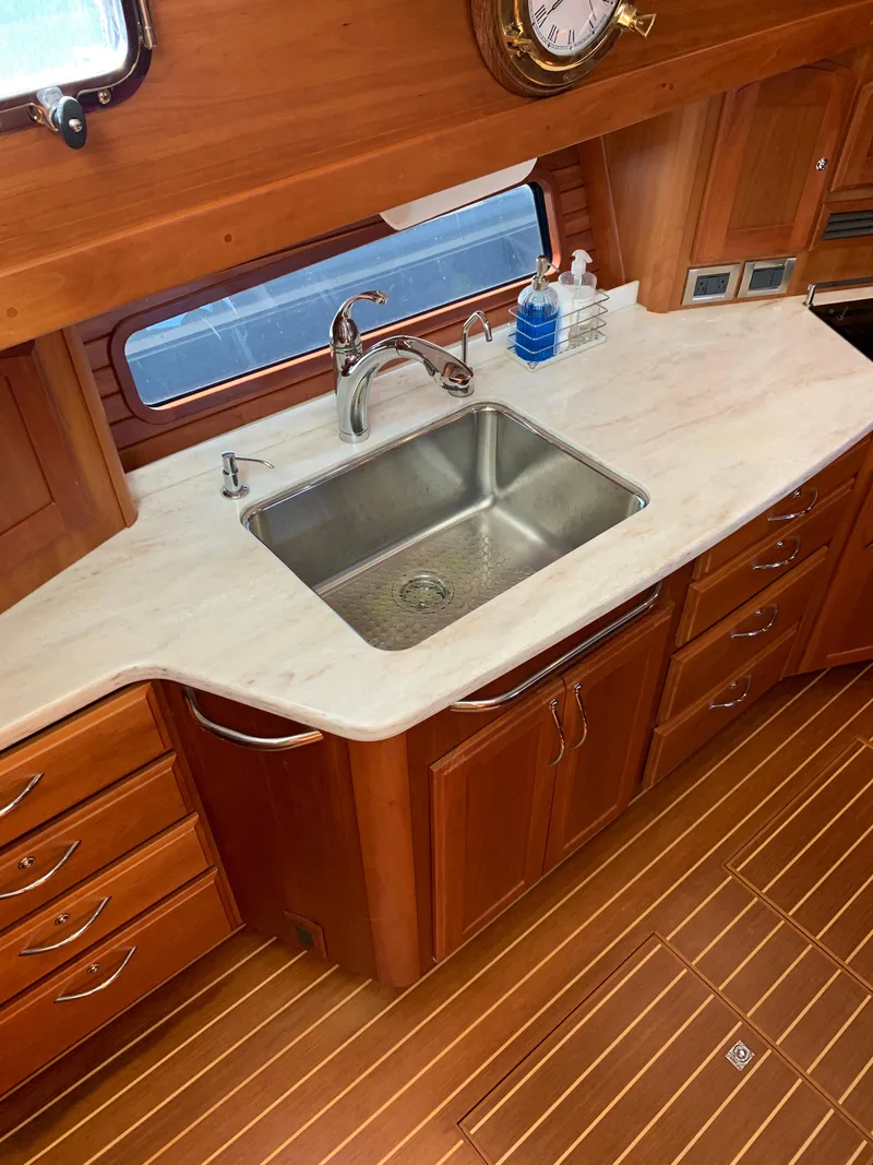 Slide: The Image of 2014 Sabre 48 Salon Express kitchen with sink, wooden cabinetry, and countertop. - 26