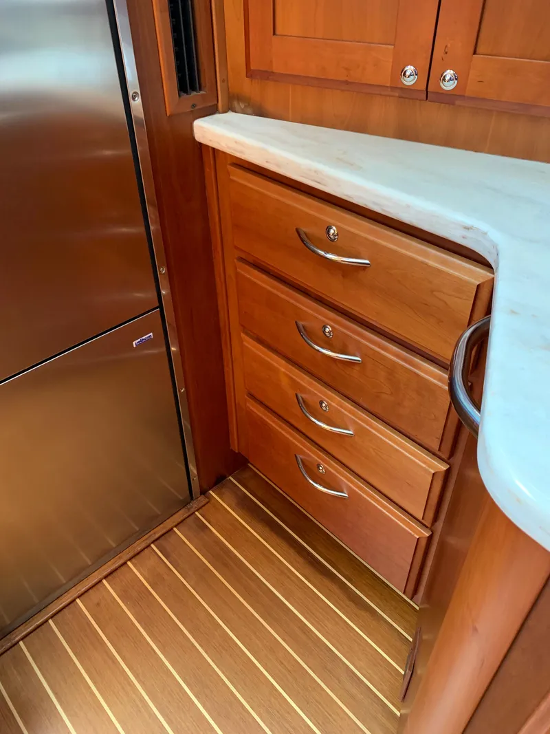Slide: The Image of 2014 Sabre 48 Salon Express interior with wooden cabinetry and stainless steel fridge. - 28