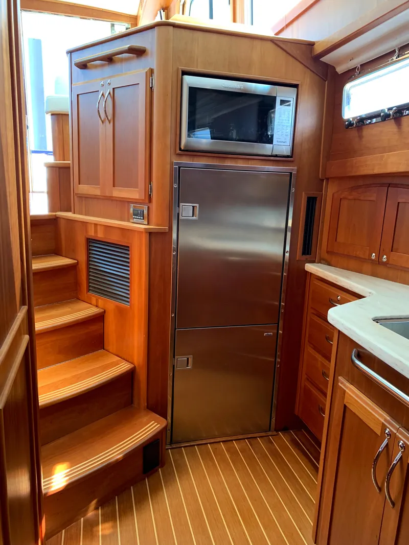 Slide: The Image of 2014 Sabre 48 Salon Express interior with wooden cabinetry and stainless steel appliances. - 29