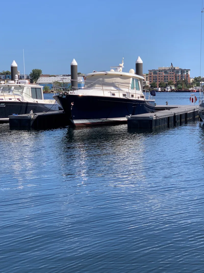Slide: The Image of 2014 Sabre 48 Salon Express yacht docked in marina under clear blue sky. - 3