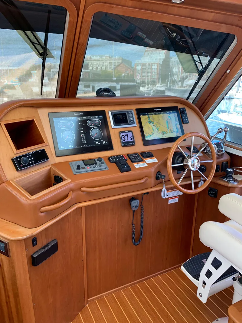 Slide: The Image of 2014 Sabre 48 Salon Express helm with navigation screens and wooden steering wheel. - 44