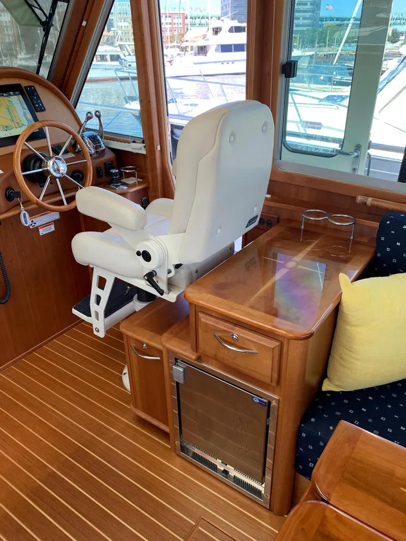 Slide: The Image of 2014 Sabre 48 Salon Express interior with captain's chair, wooden cabinetry, and navigation equipment. - 46