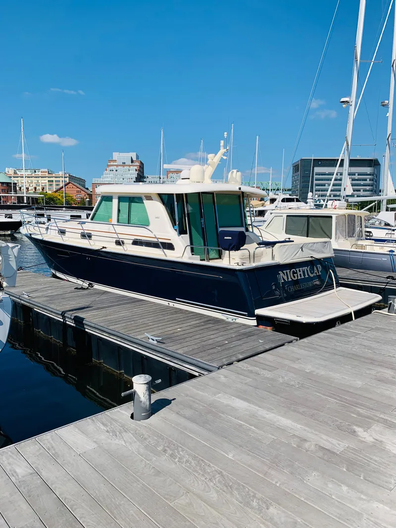 Slide: The Image of 2014 Sabre 48 Salon Express yacht docked at marina under clear blue sky. - 5