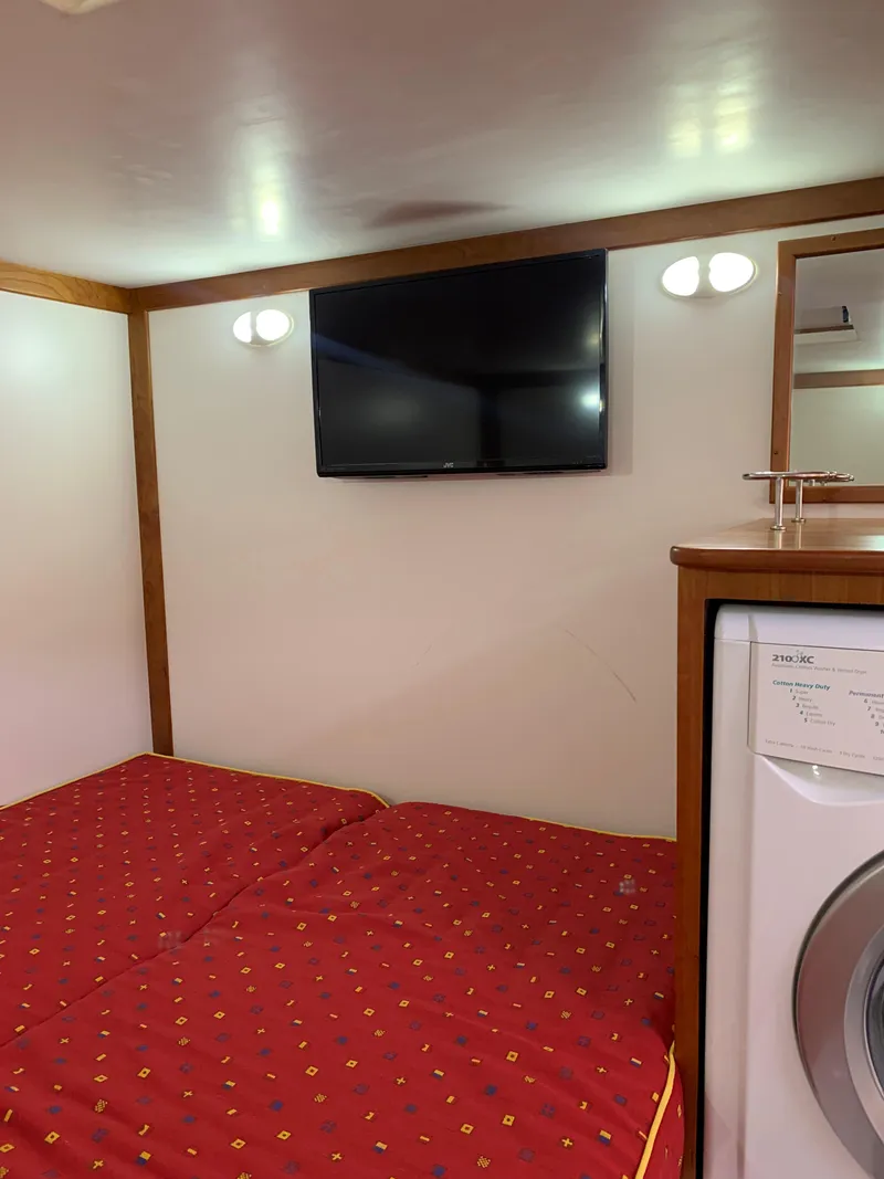 Slide: The Image of Interior of 2014 Sabre 48 Salon Express with TV, bed, and washing machine. - 50