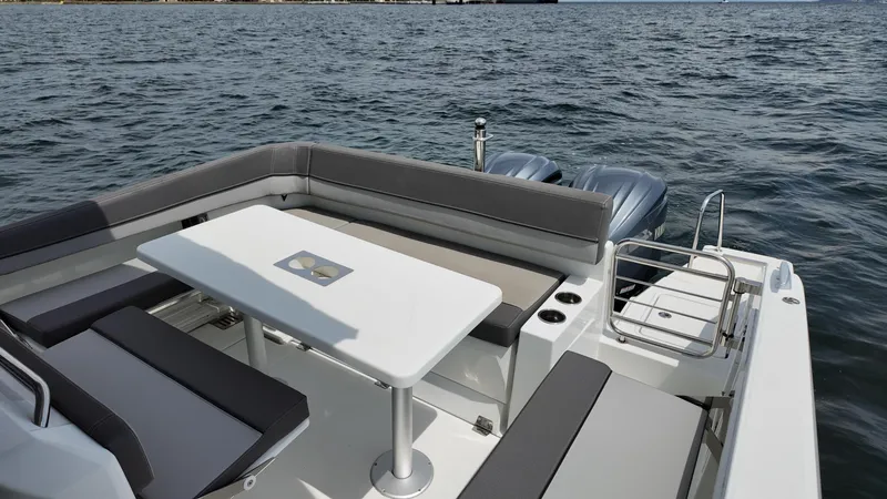 Slide: The Image of 2022 Jeanneau Leader 9.0 WA boat with seating and table on open water. - 24