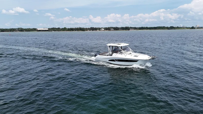 Slide: The Image of 2022 Jeanneau Leader 9.0 WA cruising on open water under a clear sky. - 8