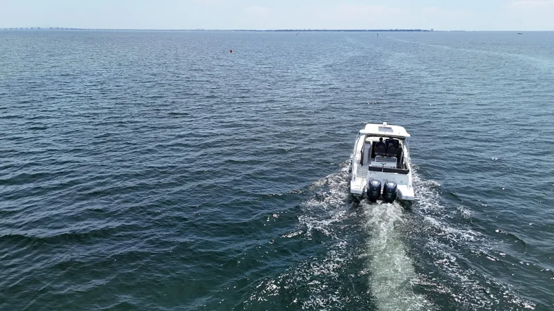 Slide: The Image of 2022 Jeanneau Leader 9.0 WA cruising on open water, rear view. - 9