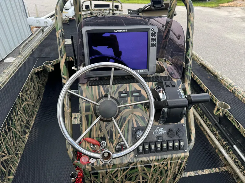 Slide: The Image of 2018 Prodigy 2172 MARSH TURF C boat dashboard with steering wheel and navigation system. - 11