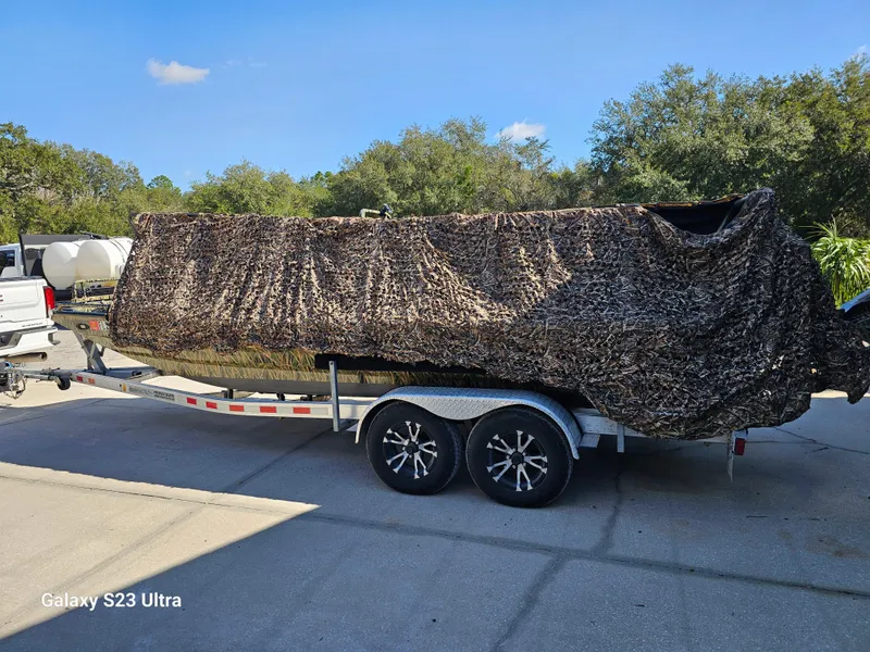 Slide: The Image of Camouflaged Prodigy 2172 MARSH TURF C boat on trailer, 2018 model, parked outdoors. - 12