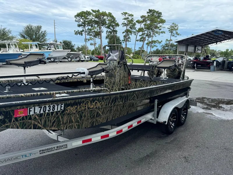 Slide: The Image of 2018 Prodigy 2172 MARSH TURF C boat on trailer, camouflage design, parked outdoors. - 4
