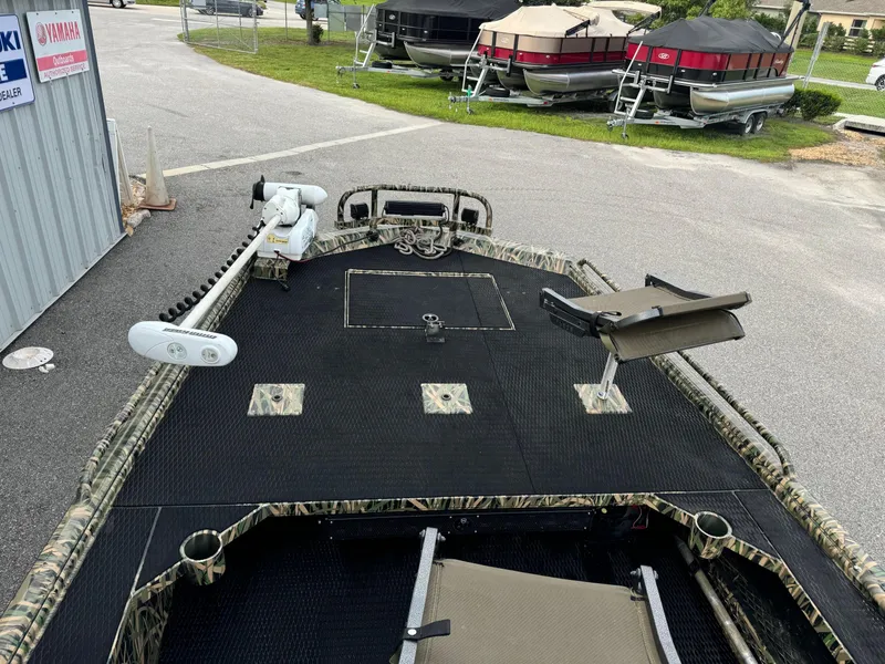 Slide: The Image of 2018 Prodigy 2172 MARSH TURF C boat with camo design, docked near other boats. - 9