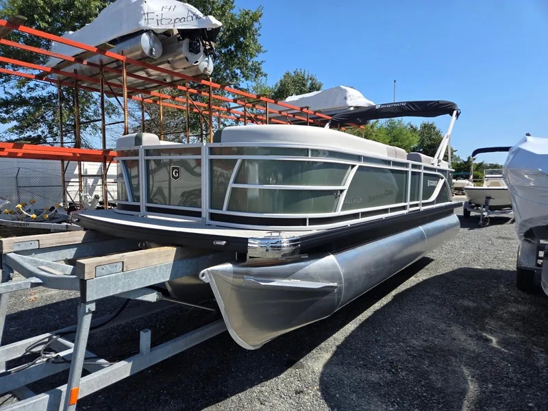 The Image of 2025 Godfrey Sweetwater 2286 C pontoon boat on trailer in outdoor storage. - 0