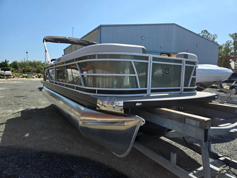 Slide: The Image of 2025 Godfrey Sweetwater 2286 C pontoon boat on trailer, parked outdoors. - 2