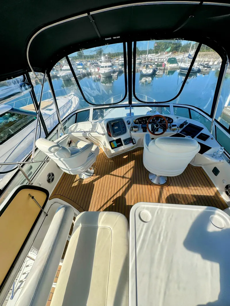 Slide: The Image of Interior view of 2001 Sea Ray 400 Sedan Bridge yacht cockpit with marina background. - 10