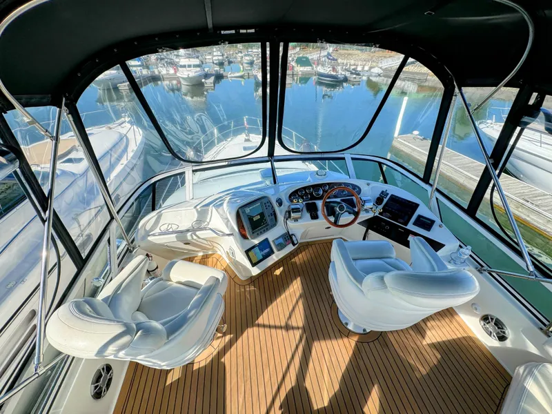 Slide: The Image of Interior view of 2001 Sea Ray 400 Sedan Bridge yacht cockpit with marina backdrop. - 11