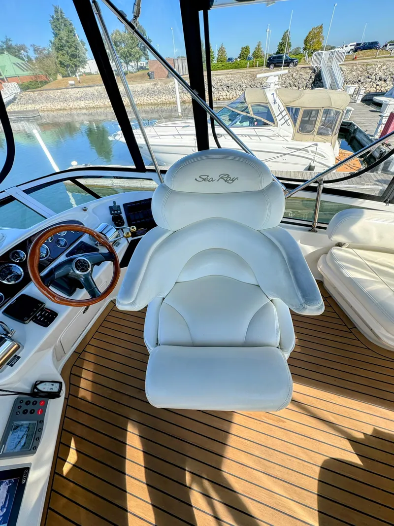 Slide: The Image of Luxurious helm of 2001 Sea Ray 400 Sedan Bridge with white captain's chair and wooden steering wheel. - 13