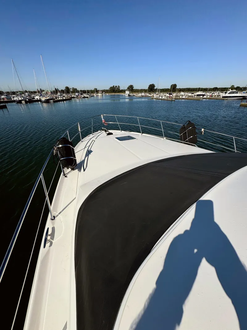 Slide: The Image of 2001 Sea Ray 400 Sedan Bridge yacht on calm water, sunny day. - 26