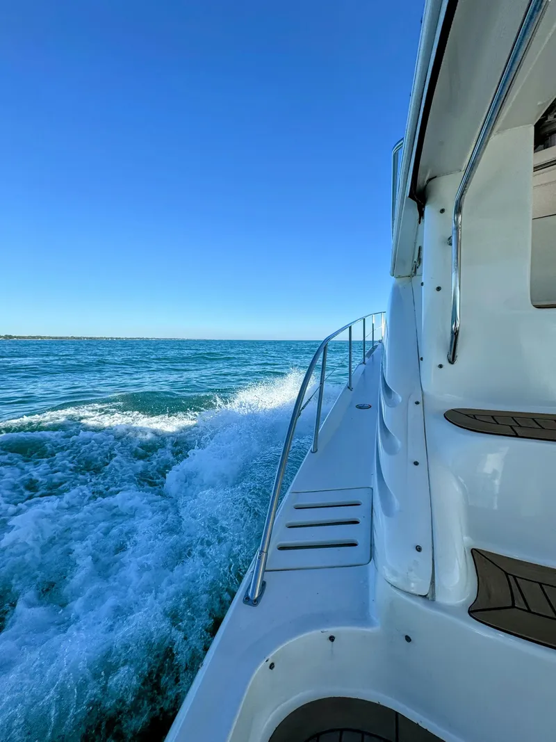 Slide: The Image of 2001 Sea Ray 400 Sedan Bridge cruising on open water under clear blue sky. - 29