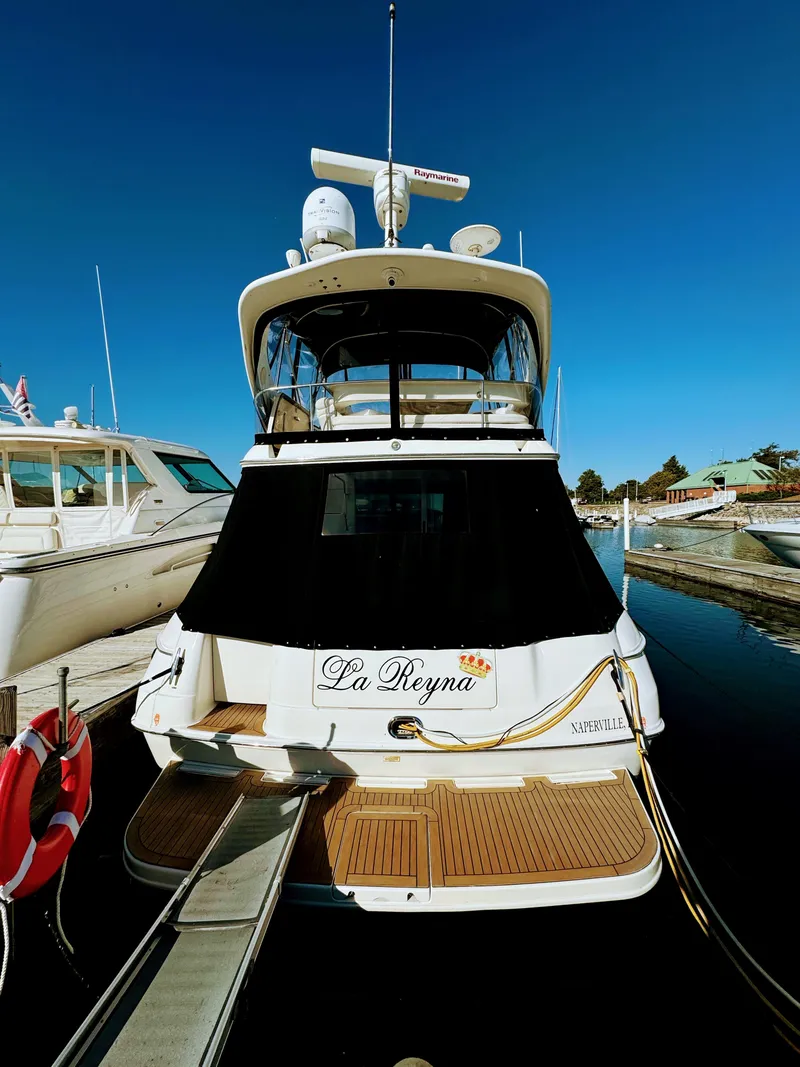 Slide: The Image of 2001 Sea Ray 400 Sedan Bridge yacht docked, rear view, named "La Reyna." - 4