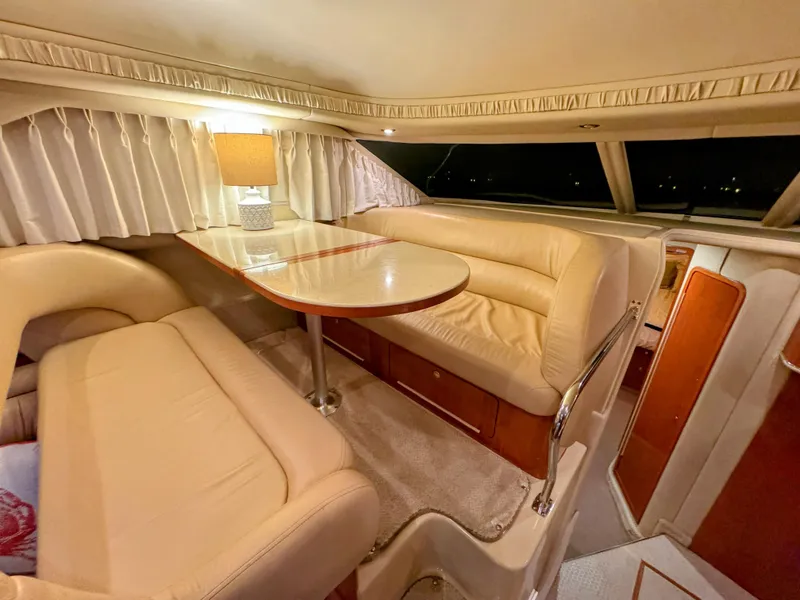 Slide: The Image of Luxurious interior of 2001 Sea Ray 400 Sedan Bridge yacht with plush seating and elegant table. - 42