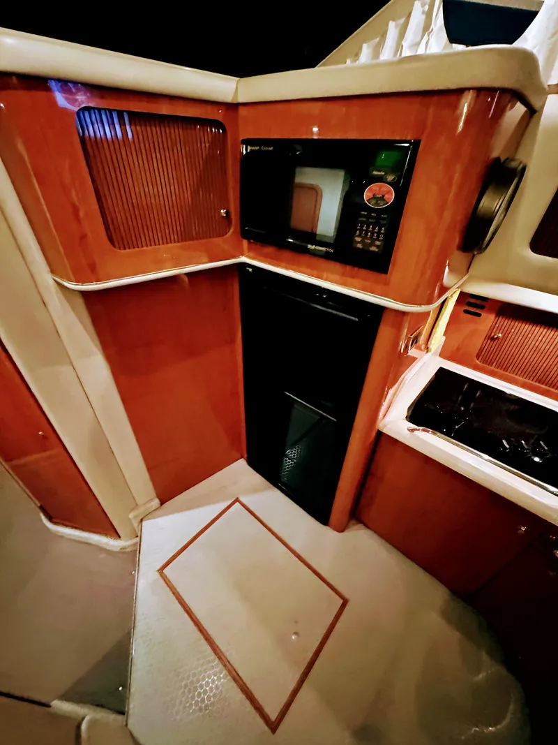 Slide: The Image of 2001 Sea Ray 400 Sedan Bridge interior kitchen with microwave and cabinetry. - 43