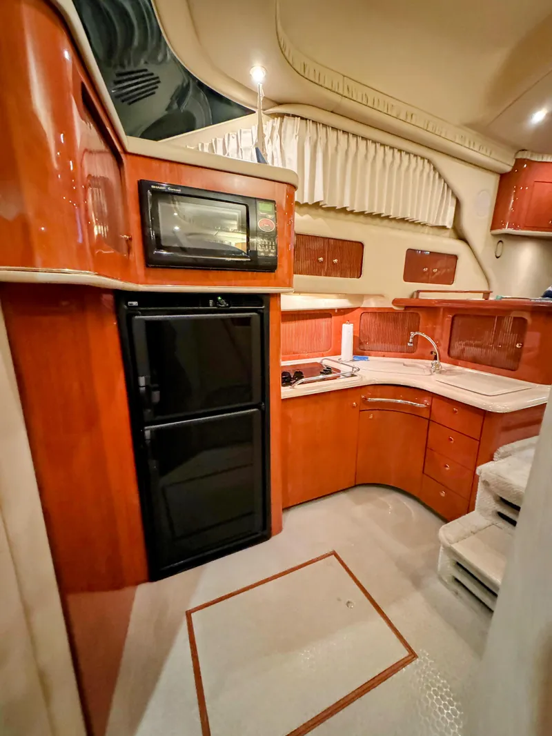 Slide: The Image of Interior of 2001 Sea Ray 400 Sedan Bridge yacht kitchen with wood cabinetry and appliances. - 44