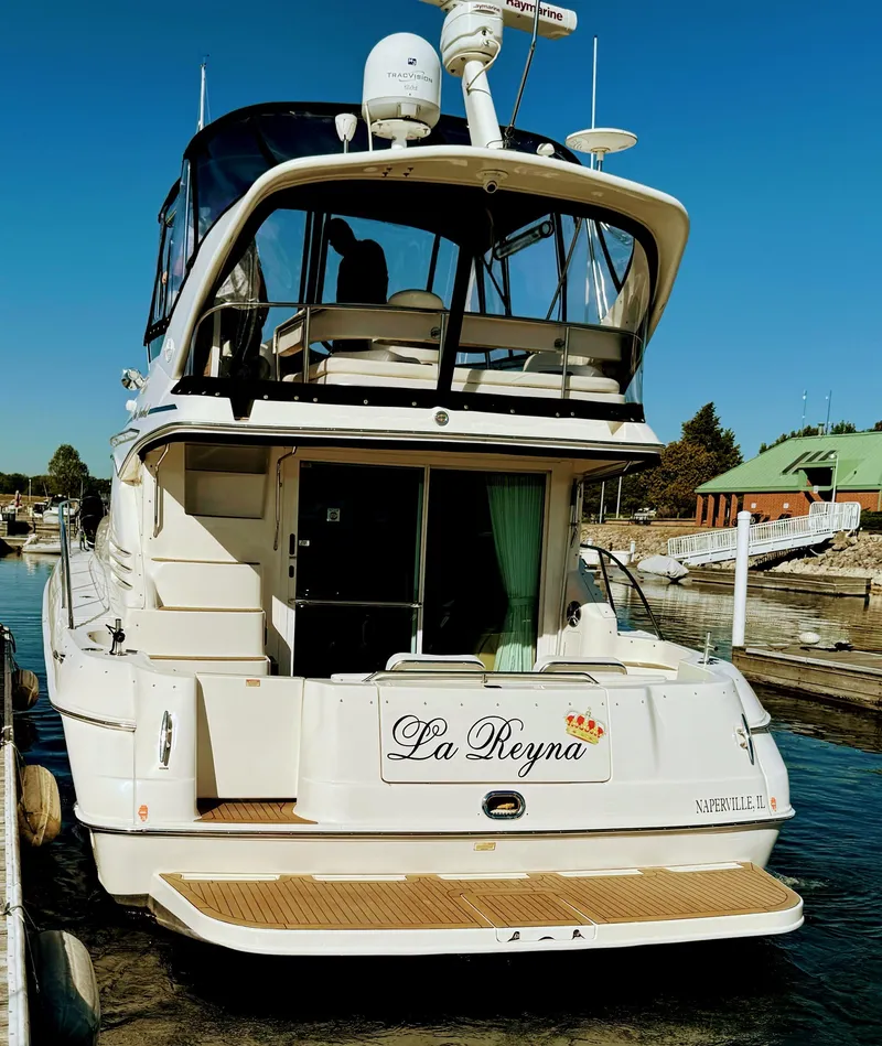 Slide: The Image of 2001 Sea Ray 400 Sedan Bridge yacht docked, rear view, named "La Reyna". - 5