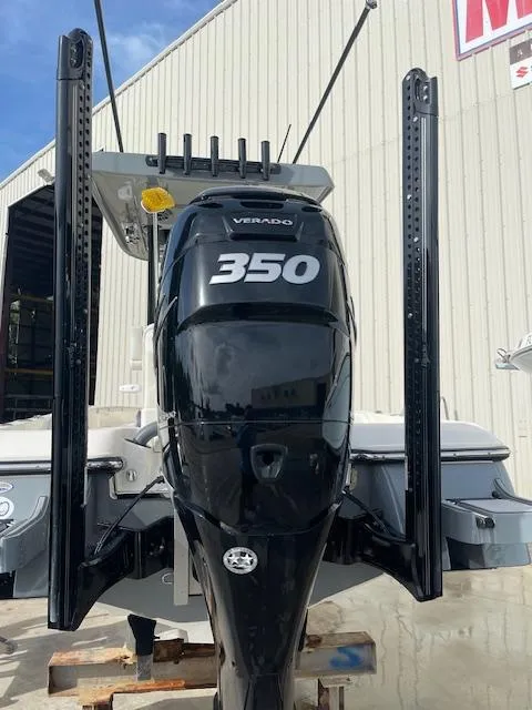 Slide: The Image of 2022 ShearWater 25 boat with a powerful 350 Verado engine, docked near a warehouse. - 4