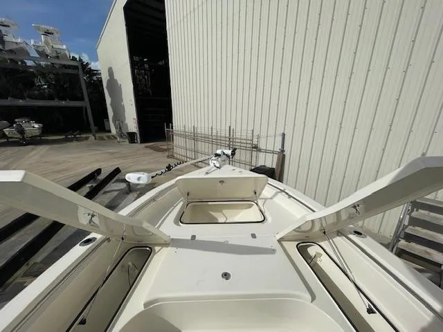 Slide: The Image of 2022 ShearWater 25 boat with open storage compartments, docked near a warehouse. - 6