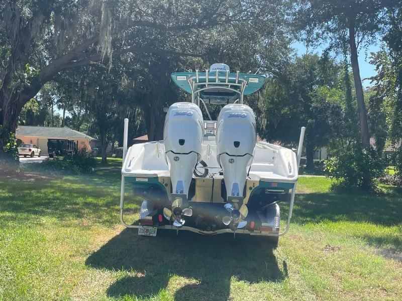 Slide: The Image of 2008 Palmetto 33 boat with dual engines, parked on grass under trees. - 15