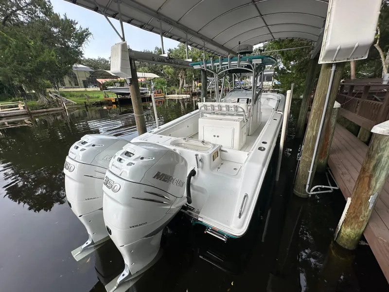 Slide: The Image of 2008 Palmetto 33 boat with twin Mercury engines docked under a canopy. - 18