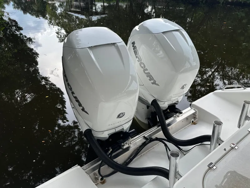 Slide: The Image of Twin Mercury outboard engines on a 2008 Palmetto 33 boat, docked on calm water. - 19