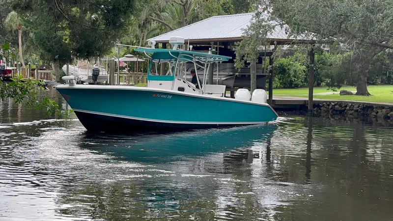 Slide: The Image of 2008 Palmetto 33 boat on a calm river near a dock and trees. - 2