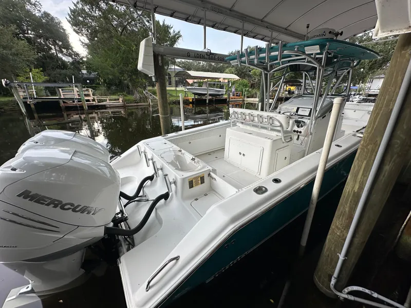 Slide: The Image of 2008 Palmetto 33 boat with Mercury engine docked under a canopy. - 24