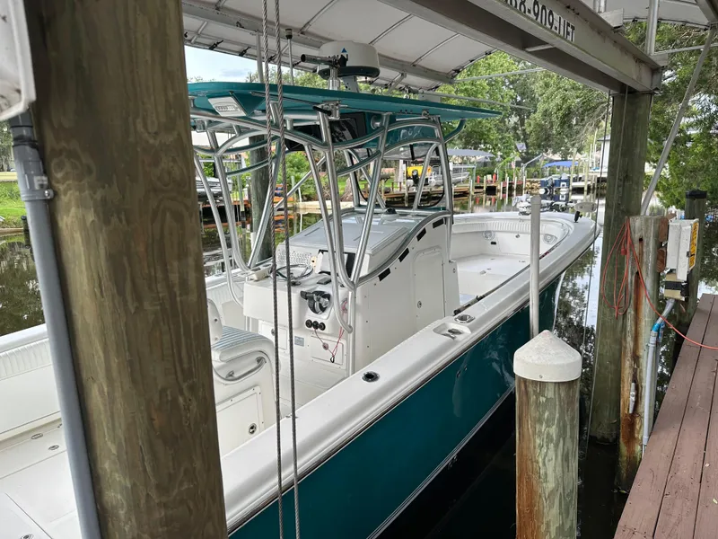 Slide: The Image of 2008 Palmetto 33 boat docked under a canopy. - 25