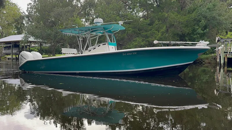 Slide: The Image of 2008 Palmetto 33 boat on calm water, surrounded by lush greenery. - 3