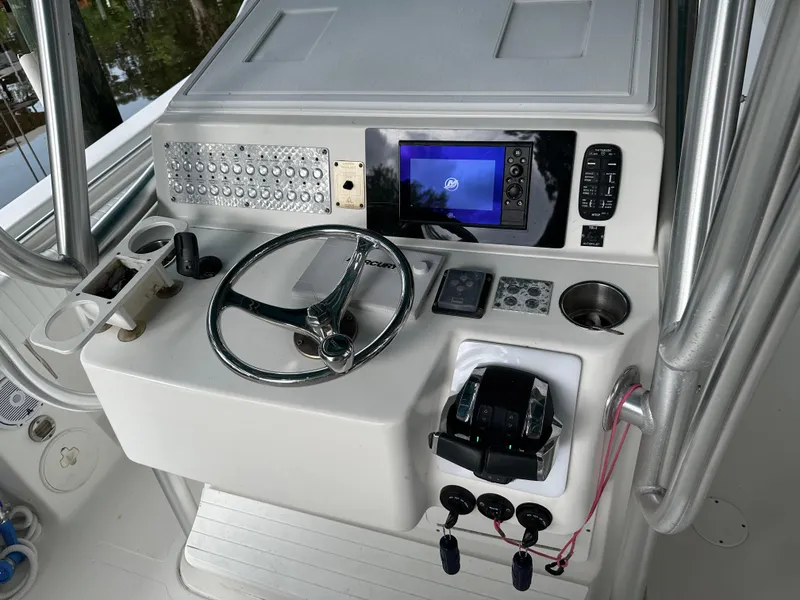 Slide: The Image of 2008 Palmetto 33 boat helm with steering wheel, controls, and navigation display. - 35