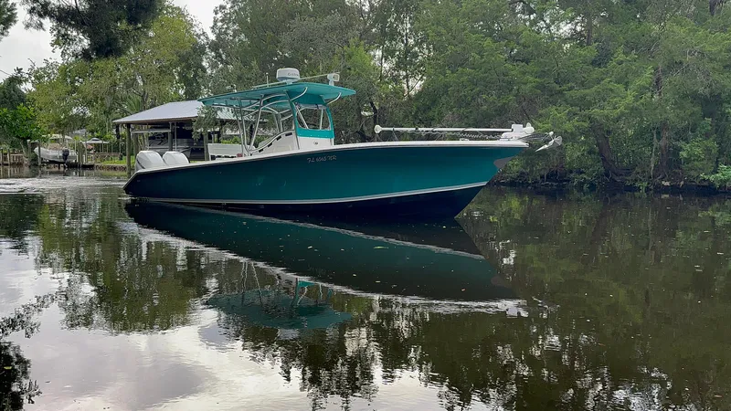 Slide: The Image of 2008 Palmetto 33 boat on a calm river, surrounded by lush greenery. - 4