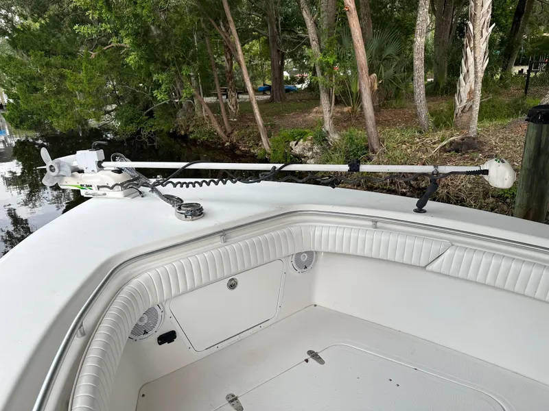 Slide: The Image of 2008 Palmetto 33 boat bow with trolling motor, docked near lush greenery. - 48