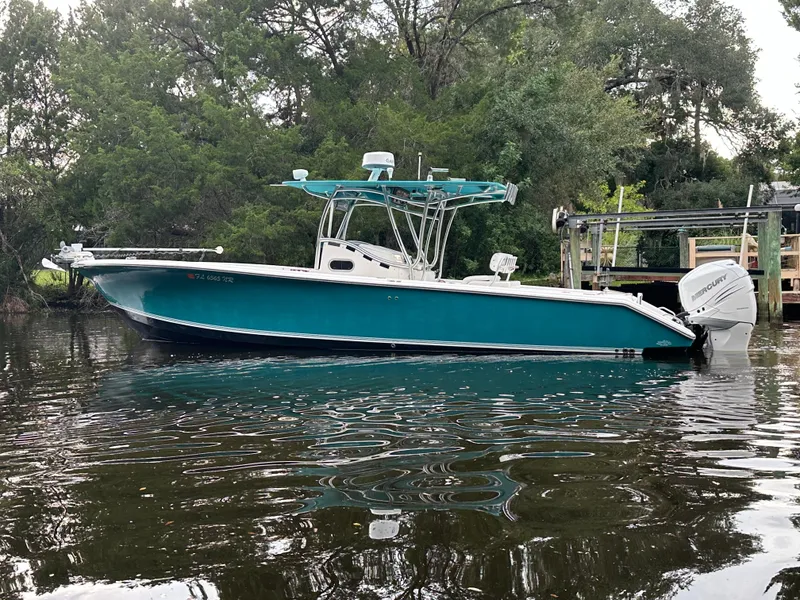 Slide: The Image of 2008 Palmetto 33 boat on calm water, surrounded by lush greenery. - 6