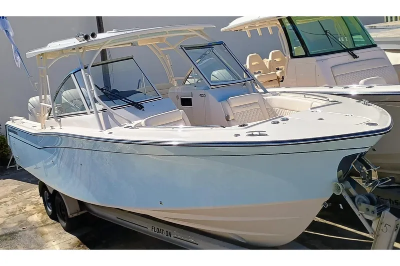 Slide: The Image of 2025 Grady-White Freedom 307 boat on trailer, sleek design, dual console, white exterior. - 0