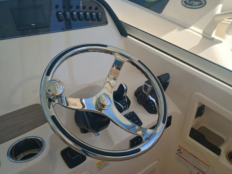Slide: The Image of Steering wheel and controls of 2025 Grady-White Freedom 307 boat cockpit. - 11