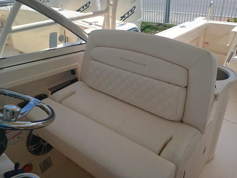 Slide: The Image of 2025 Grady-White Freedom 307 boat interior with beige seating and steering wheel. - 13