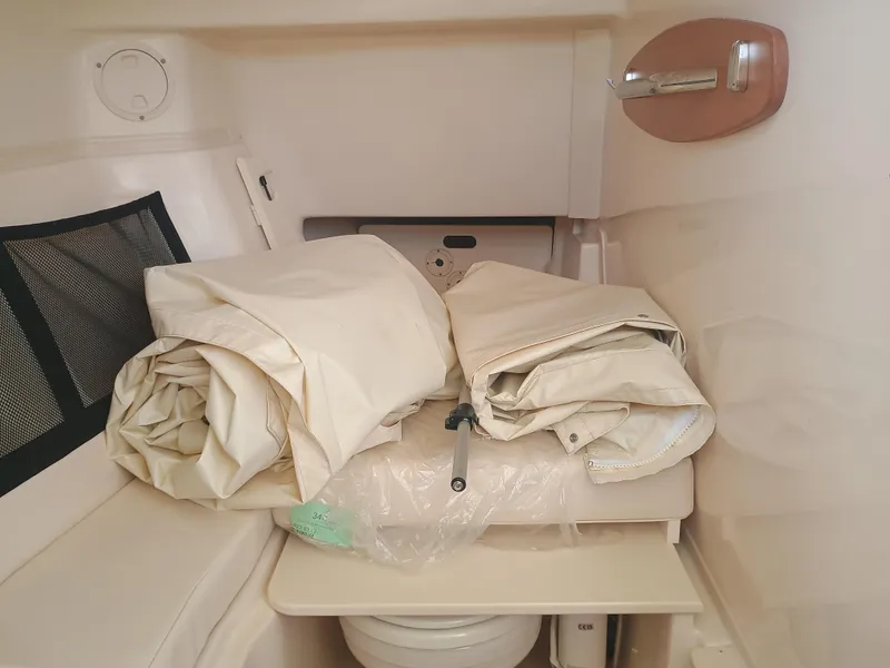 Slide: The Image of 2025 Grady-White Freedom 307 cabin interior with folded canvas and storage. - 20