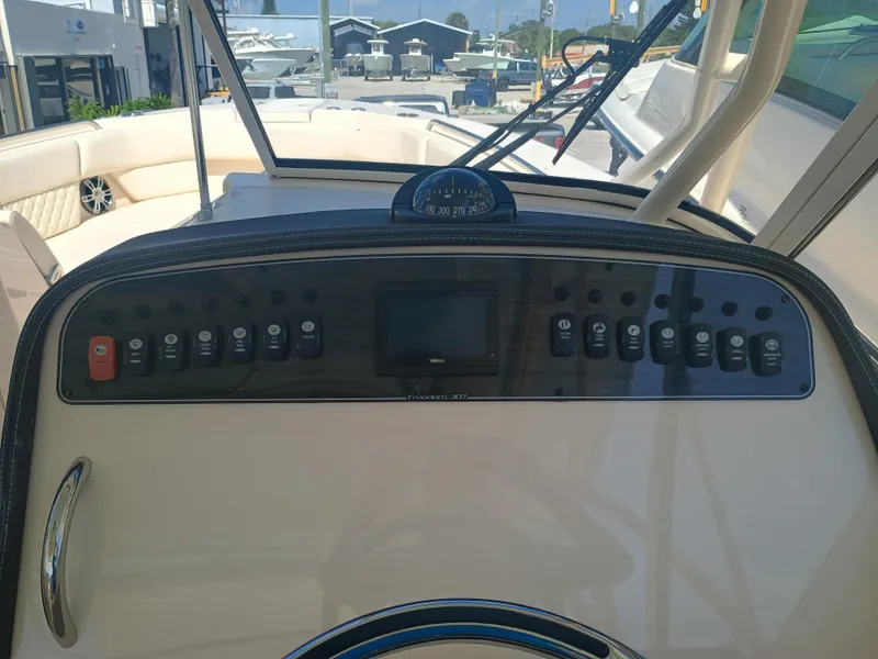 Slide: The Image of 2025 Grady-White Freedom 307 boat dashboard with control panel and navigation instruments. - 7